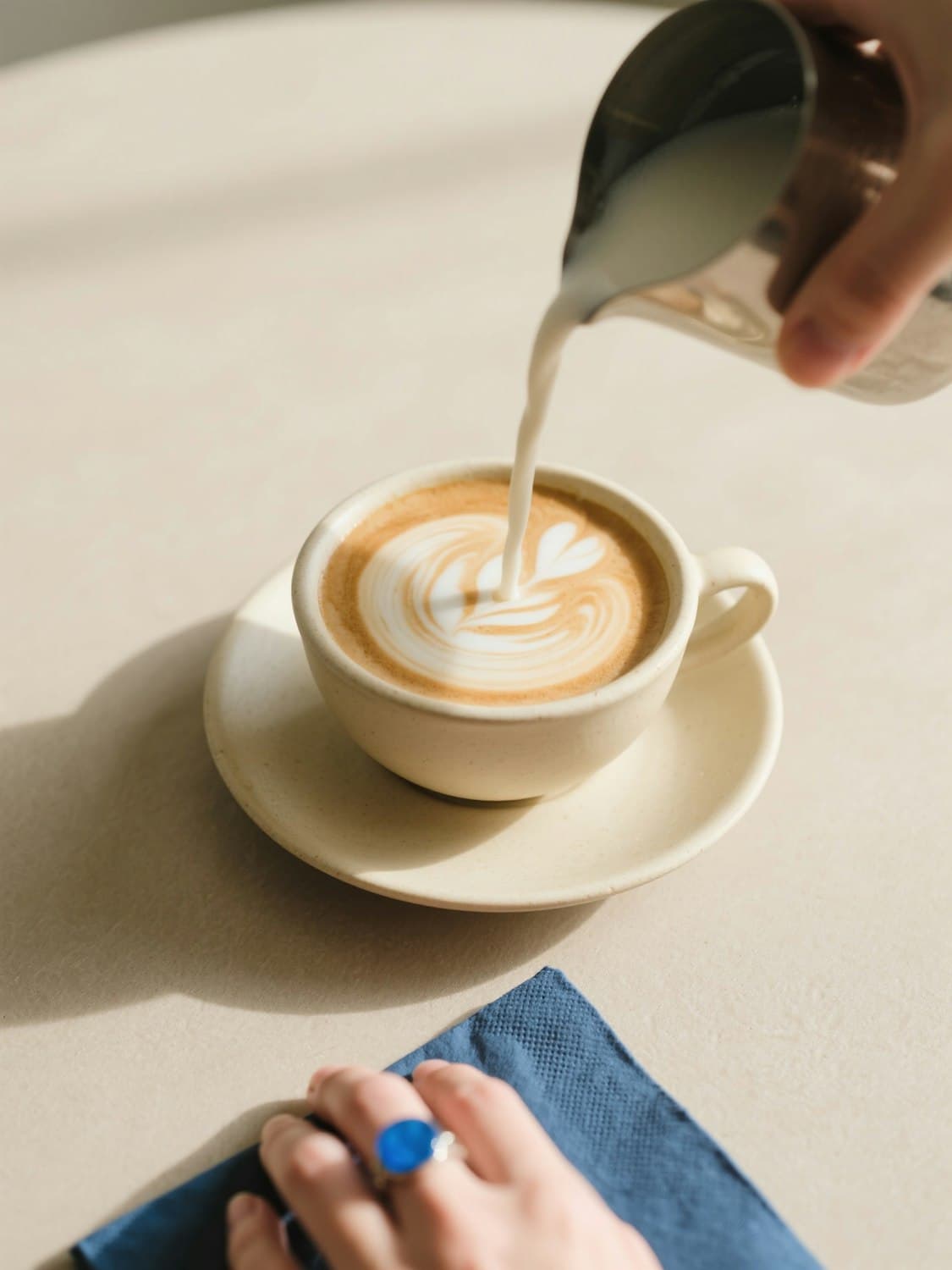 Steamed milk being poured into a cappuccino to draw latte art